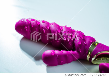 Wet Magenta colored ribbed vibrator in water. 128253785