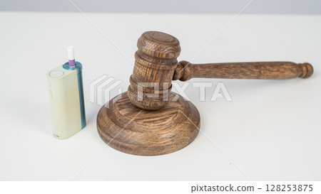 Judge's gavel and e-cigarette. Smoking ban. Tobacco heating systems.  128253875