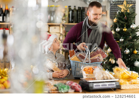 Man and boy choosing chips in grocery store 128254601