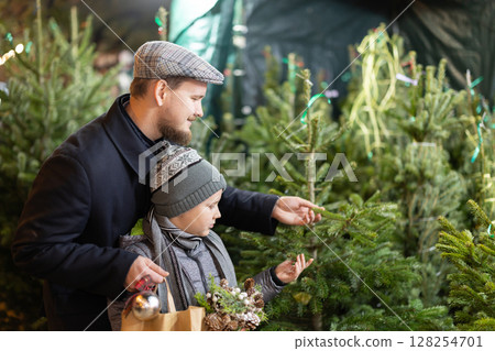 Man and his son choose a Christmas tree Man and his son choose a Christmas tree 128254701