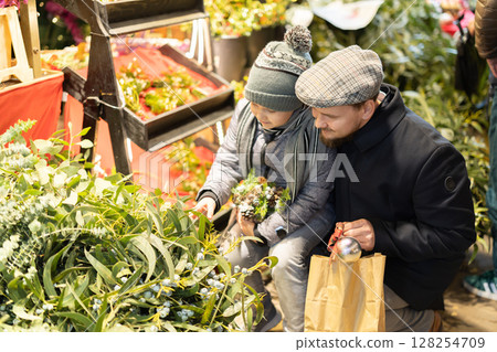 Man and his son choose plant branches for decoration 128254709