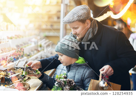 Father and son choose figures for the nativity scene 128254935