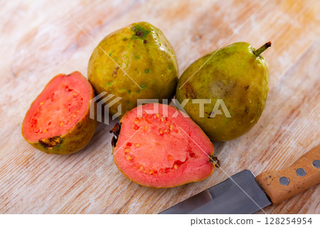 Fresh whole and sliced guava fruits on wooden table 128254954