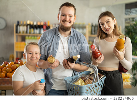 Positive family with little son choosing drinks in supermarket Positive family with little son choosing drinks in supermarket 128254966