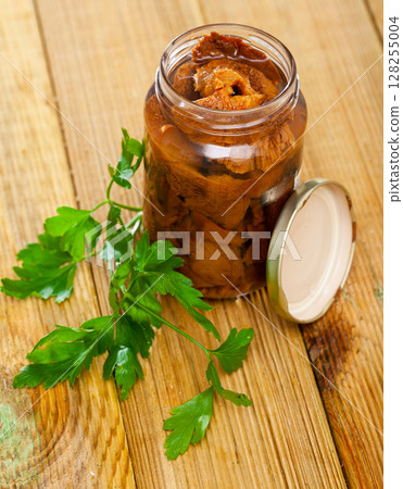 Pickled red pine mushrooms in open jar with parsley Pickled red pine mushrooms in open jar with parsley 128255004