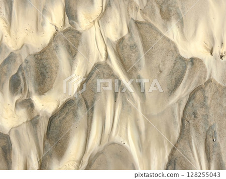 natural patterns in sand and clay create unique textures under sunlight at beach. closeup. 128255043