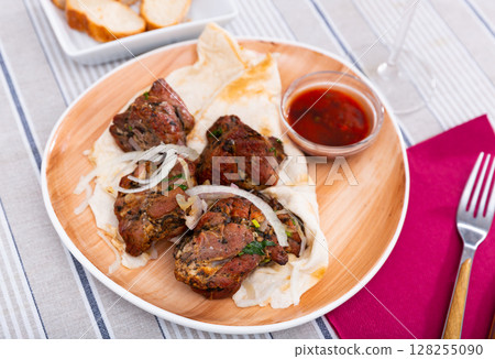 Grilled pork meat shashlik with marinated onion 128255090