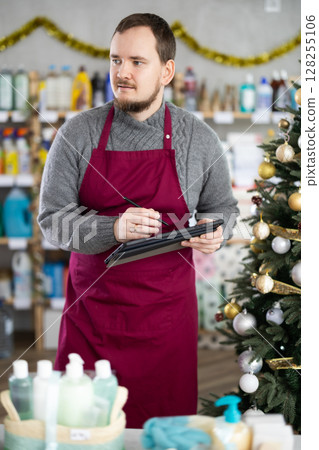 Cleaning supplies store owner reviewing stock levels on tablet 128255106