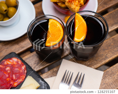 Red vermouth garnished with orange served with Spanish tapas 128255107