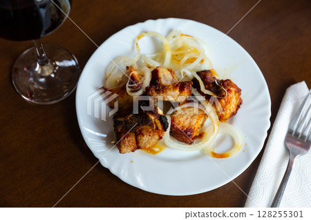 Grilled pork shashlik with fresh onion on plate 128255301