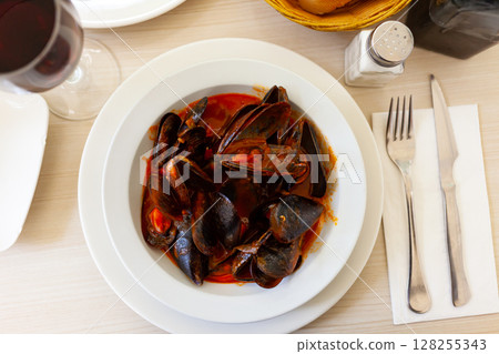 Delicious boiled mussels with tomato sauce and parsley Delicious boiled mussels with tomato sauce and parsley 128255343