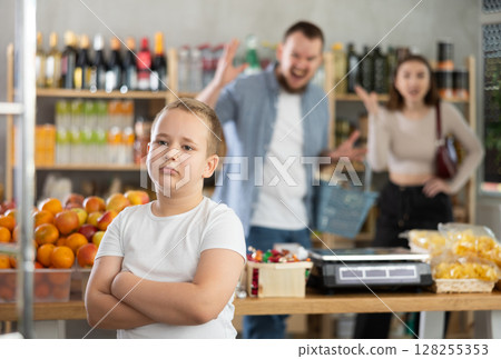 Couple man and woman quarreling with boy in grocery store Couple man and woman quarreling with boy in grocery store 128255353