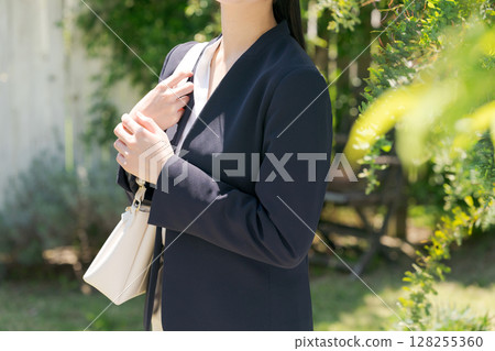 一位身穿西裝的女士站在白牆前 一位身穿西裝的女士站在白牆前 128255360