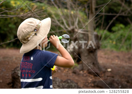 <Material> A boy blowing soap bubbles in the park <Material> A boy blowing soap bubbles in the park 128255828
