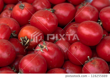 Close-up view of many ripe red tomatoes piled together in bulk 128255889
