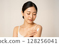 A woman applying UV cream 128256041