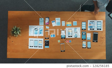 Top view of software developer holding tablet while choosing icon. Convocation. 128256185