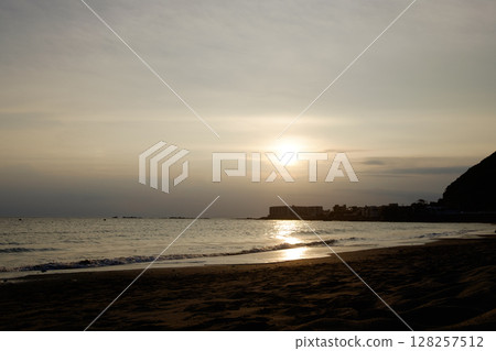 初夏平靜的海面、岬角和沙灘，被夕陽染成金色 128257512