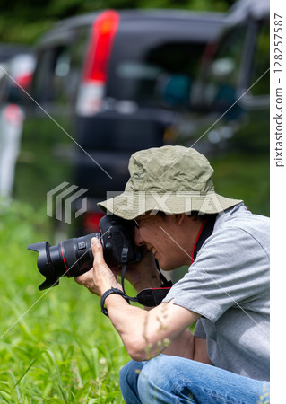 Cameraman grandfather taking pictures outdoors 128257587