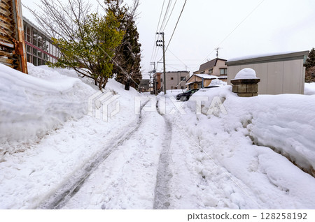 雪域居民區道路。汽車輪胎留下的車轍使這些道路難以行走。 雪域居民區道路。汽車輪胎留下的車轍使這些道路難以行走。 128258192