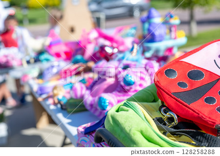 Pile of secondhand cloths on a folding table of a yard sale Pile of secondhand cloths on a folding table of a yard sale 128258288