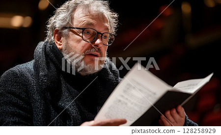 Man reading documents close up portrait dark clothing serious expression 128258929
