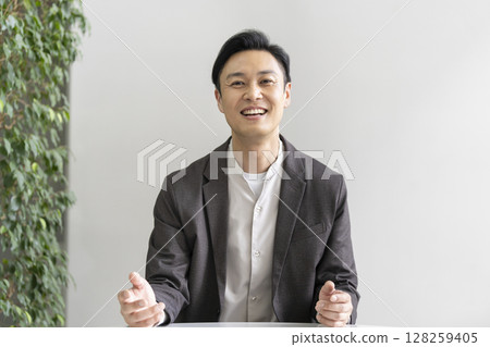 A man in his 40s smiling and talking to the camera A man in his 40s smiling and talking to the camera 128259405