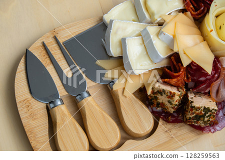 Wooden charcuterie cheese board holiday present idea. Snack starter plate for dinner with wine. Italian appetizers or antipasto set with gourmet food. Buffet party Wooden charcuterie cheese board holiday present idea. Snack starter plate for dinner with wine. Italian appetizers or antipasto set with gourmet food. Buffet party 128259563
