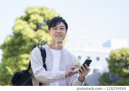 一名 40 多歲的男子手持智慧型手機，看著鏡頭 128259569