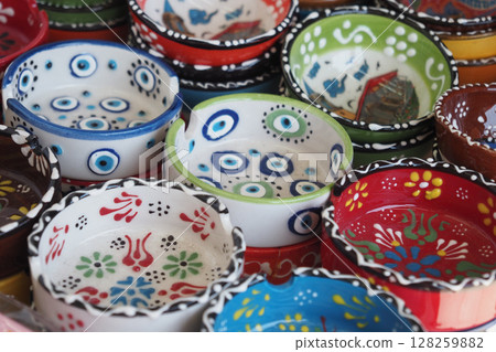 Colorful hand-painted ceramic bowls displayed at a market 128259882