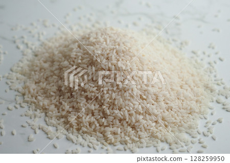 White rice piled on a clean kitchen surface 128259950