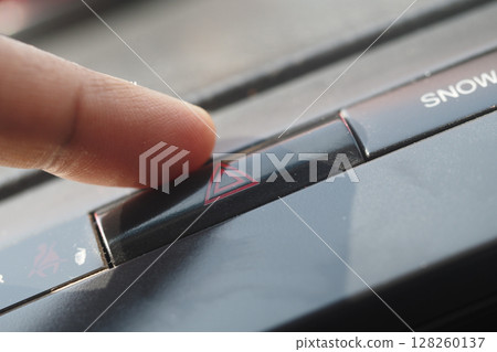 Finger pressing hazard light button inside vehicle Finger pressing hazard light button inside vehicle 128260137