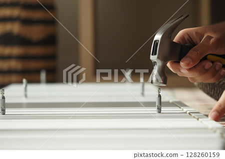 Building furniture with a hammer in a workshop Building furniture with a hammer in a workshop 128260159