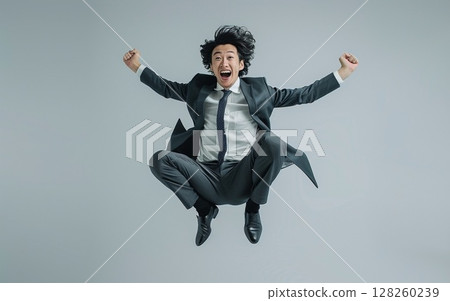 A businessman in a suit is jumping 128260239