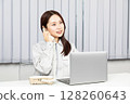 穿著工作服的女人接電話並在電腦上工作 03 128260643