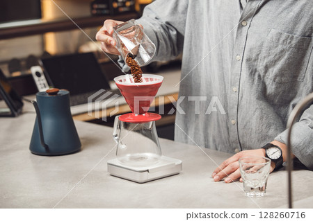 Barista Precision: Pouring Freshly Ground Coffee Into Pour-Over Filter at Modern Cafe 128260716