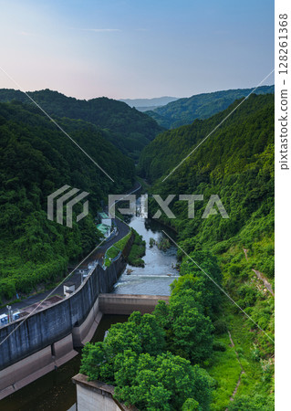 Nara Nunome Dam in midsummer. Scenery of the downstream area of the Nunome River on the north side of the dam. Kasagi Mountain in the distance and a valley covered in deep greenery. 128261368