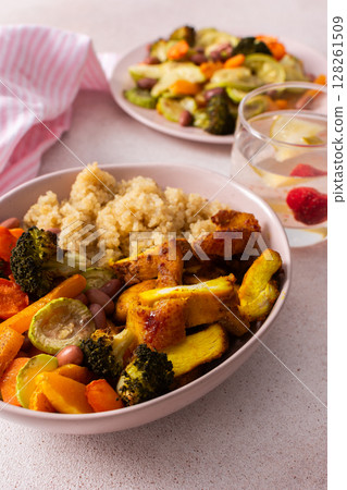 A well-balanced breakfast spread showcasing quinoa, baked sweet potato with carrots, zucchini, broccoli, beans, and baked chicken breast seasoned with turmeric 128261509