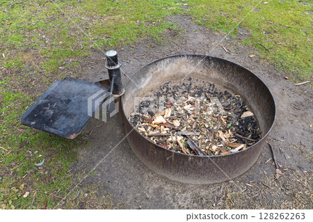 A steel ringed fire pit in a large family campground in the mountains 128262263