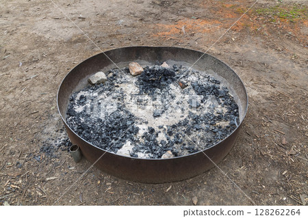 A steel ringed fire pit in a large family campground in the mountains A steel ringed fire pit in a large family campground in the mountains 128262264