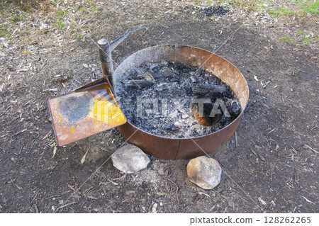 A steel ringed fire pit in a large family campground in the mountains 128262265