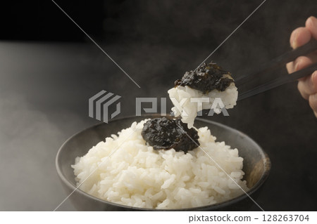 用筷子夾起鋪著海苔佃煮的米飯 用筷子夾起鋪著海苔佃煮的米飯 128263704