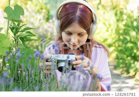 Young girl exploring nature with vintage camera 128263781