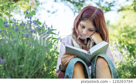 Young girl reading a book in a lavender garden 128263784