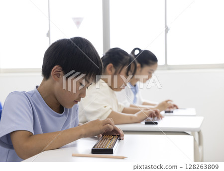 Elementary school student using abacus 128263809