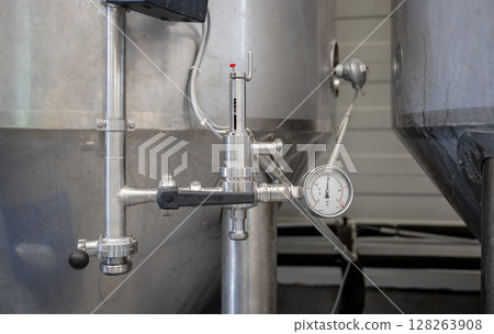 Pressure valve and gauge on stainless steel fermentation tank in modern craft brewery 128263908