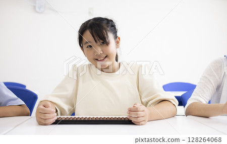 Elementary school student using abacus Elementary school student using abacus 128264068