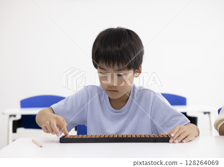 Elementary school student using abacus 128264069