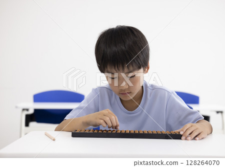 Elementary school student using abacus 128264070