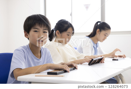 Elementary school student using abacus 128264073